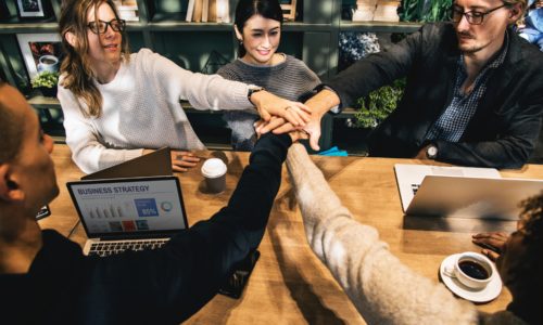 People linking hands in a meeting