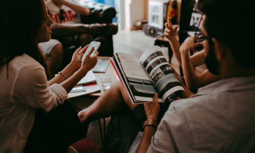 People sitting in a group with smartphones and books